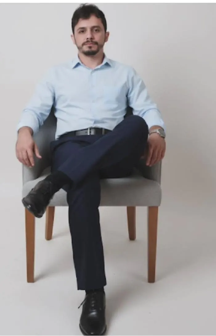 João Paulo de Souza Moreira, de camisa azul-clara, sentado numa poltrona