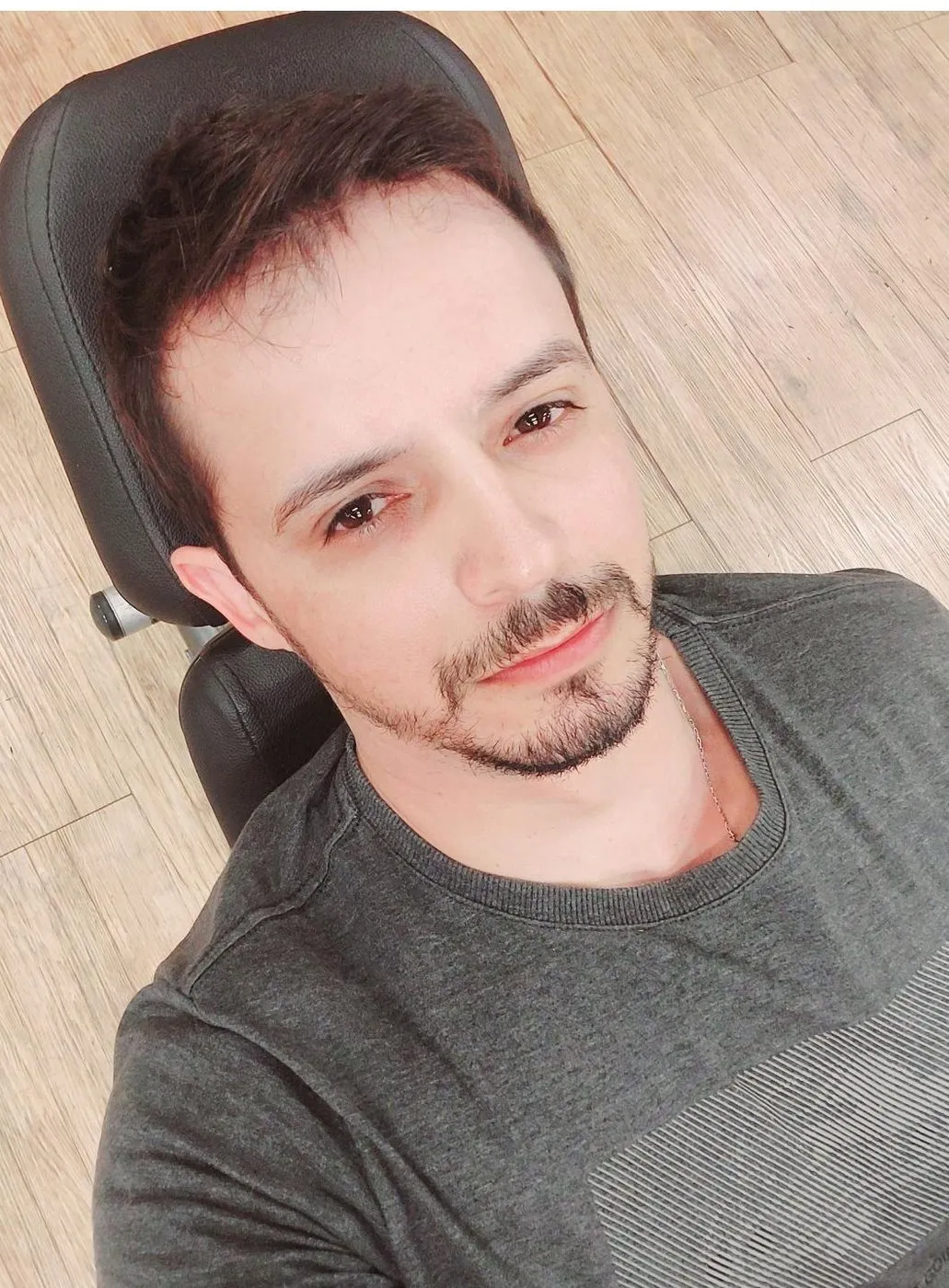 João Paulo de Souza Moreira, sorrindo, de camiseta cinza